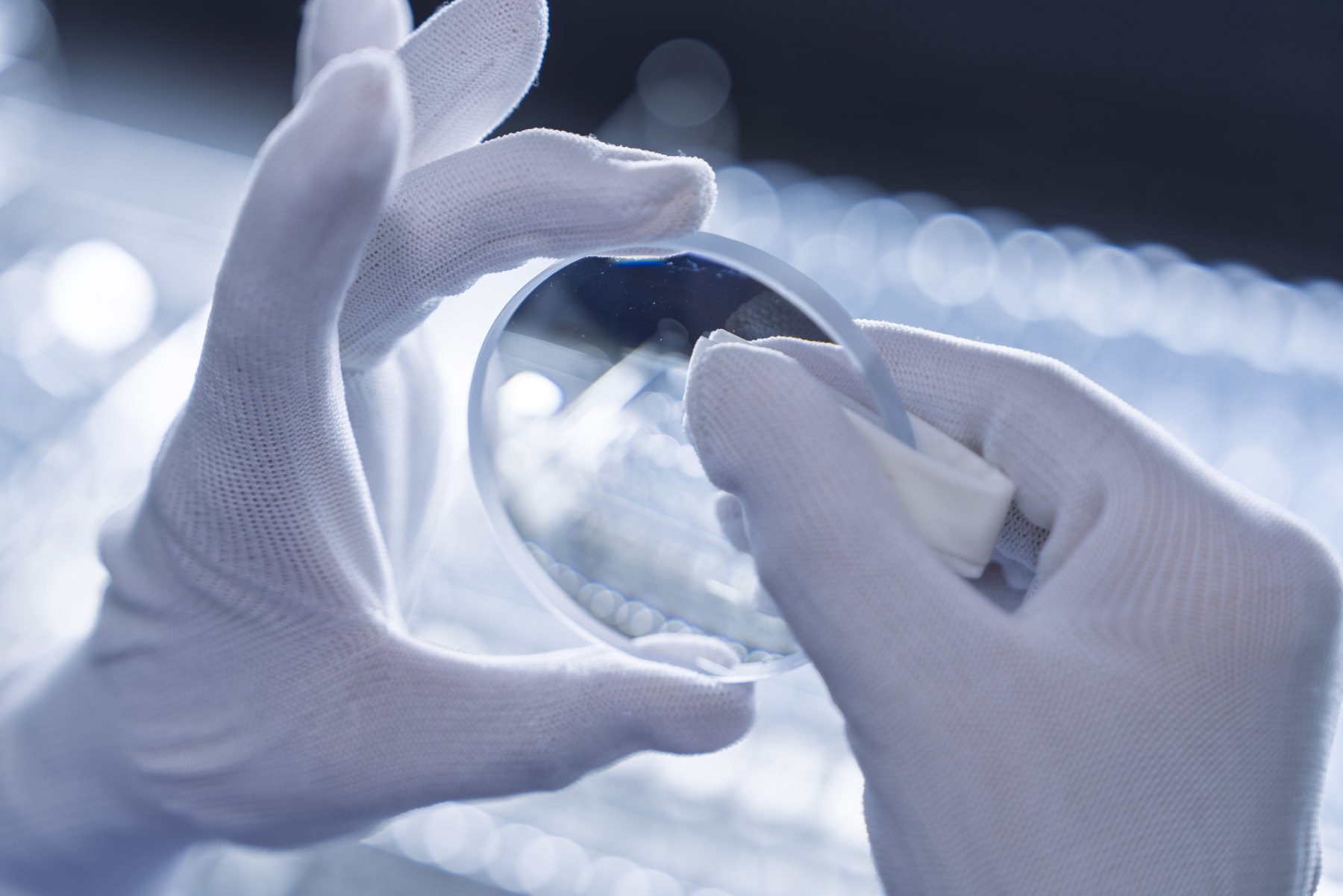 A finished lens being checked by hand